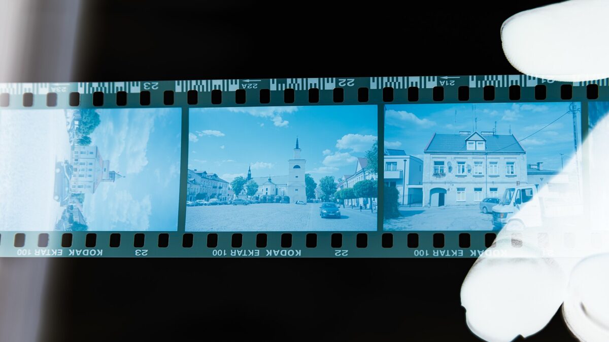 A color photographic film negative held in a hand, illustrating sections of a video file