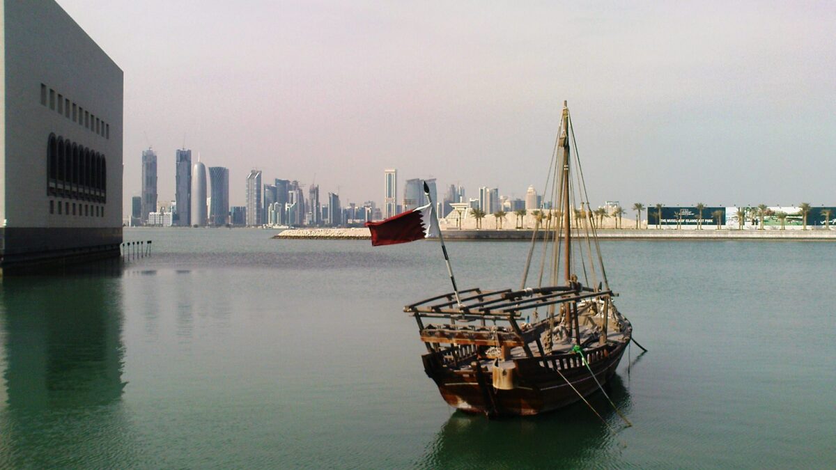 Qatar flag flying beside the Doha skyline in a 2010 photograph